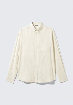 Biely textúrovaný košeľa s dlhými rukávmi, golierom na gombíky a jednou náprsní kapsou. Značková nálepka "WEEKDAY" viditeľná vo vnútri goliera.