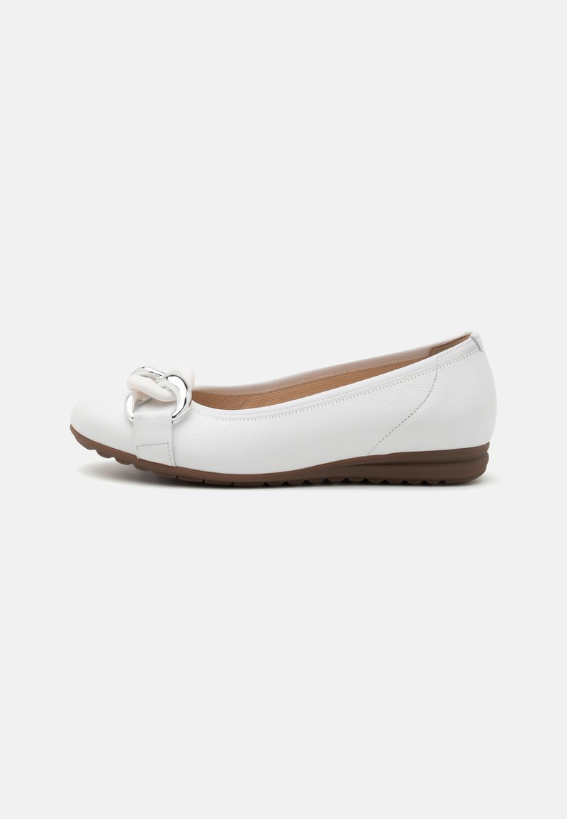 Des ballerines blanches en cuir avec un bout arrondi, un grand détail de boucle métallique et une semelle en caoutchouc brun flexible.