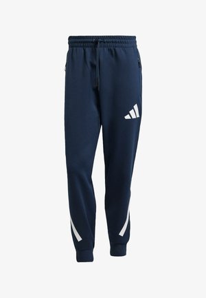 Pantaloni sportivi blu navy con vita elasticizzata, cordoncino, tasche laterali e strisce bianche a contrasto con logo sulla gamba sinistra.