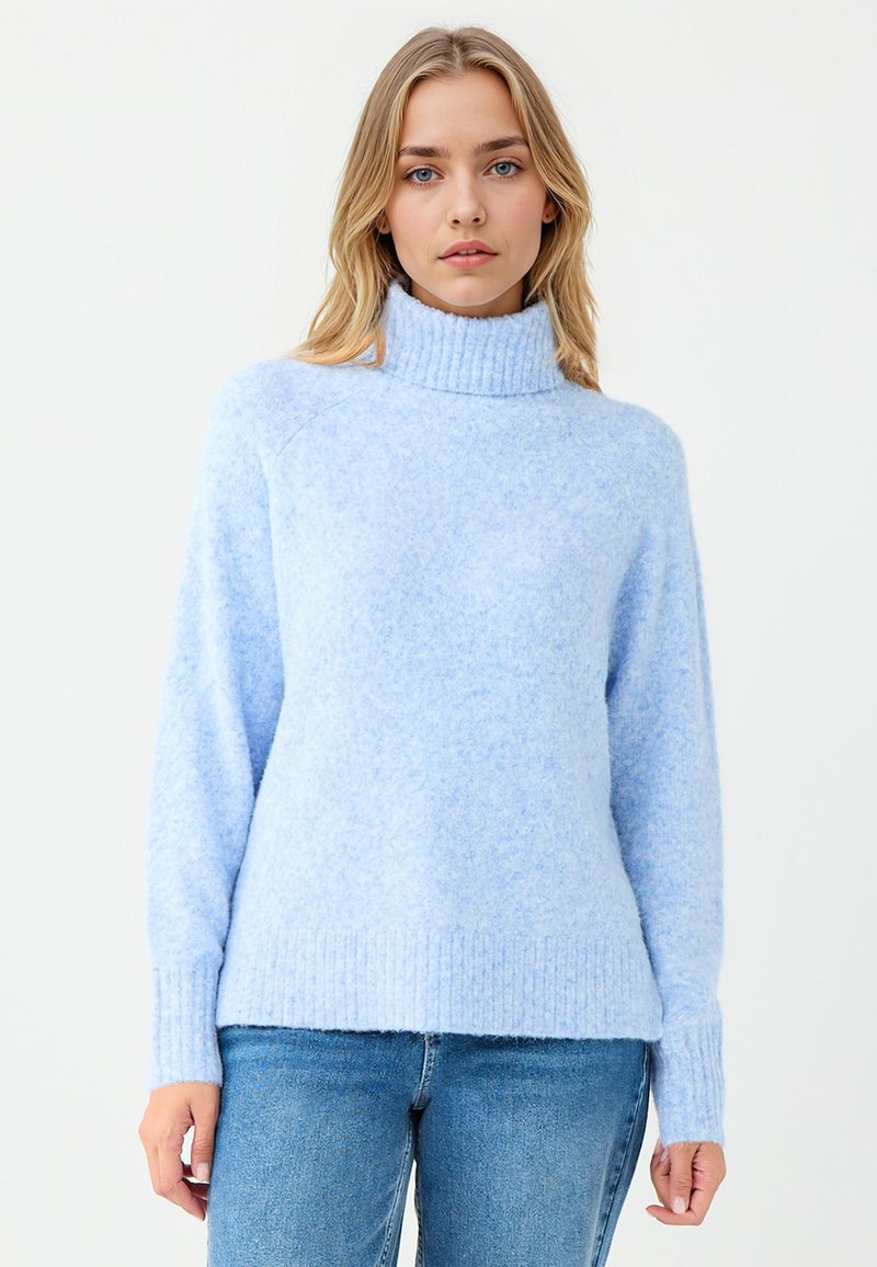 Helles blaues Rollkragensweatshirt aus weichem, strukturiertem Stoff mit gerippten Bündchen und Saum. Kombiniert mit blauen Jeans in lockerer Passform.