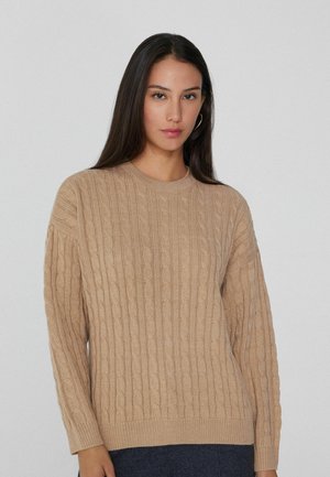 Beige gestrickter Pullover mit einem strukturierten Zopfmuster, Rundhalsausschnitt und langen Ärmeln. Das Material wirkt weich und leicht.