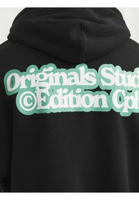 Černá mikina s kapucí a velkým mintově zeleným grafickým textem na zádech, který zní „Originals Studio © Edition Cph.“ Měkká tkanina a ležérní design.