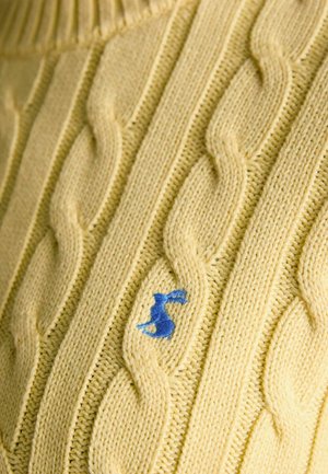 Yellow cable-knit fabric with a small blue embroidered rabbit logo integrated into the knit pattern.