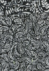 Tessuto a motivi in bianco e nero con intricati disegni paisley e motivi vegetali, caratterizzato da una texture morbida e una forma fluida.