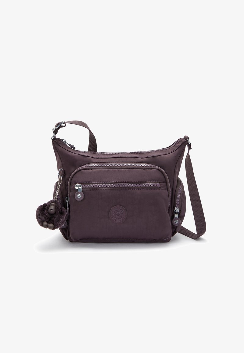 Borsa a tracolla in nylon viola con tracolla regolabile, numerose tasche con zip, un patch rotondo con logo e un portachiavi a forma di scimmia pelosa.