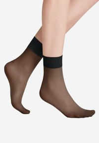 Przezroczyste czarne skarpetki sięgające kostek z jednolitą czarną opaską na górze. Miękka tekstura, lekka konstrukcja i przezroczysty wygląd na stopie.
