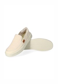 Scarpe slip-on beige chiaro con tomaia in tessuto testurizzato, suola in gomma e un piccolo logo marrone come accento. L'interno presenta una fodera a righe.