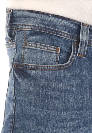 Jeans in denim di colore azzurro chiaro, con una tasca anteriore, cuciture a contrasto e una vestibilità slim. Il tessuto ha una texture liscia.