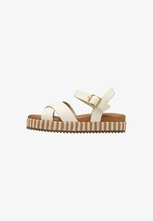 Weiße Leder-Plateausandalen mit kreuzweise angeordneten Riemen, verstellbarem Schnallenverschluss und strukturiertem Fußbett mit braun- und cremefarbenen Streifen.