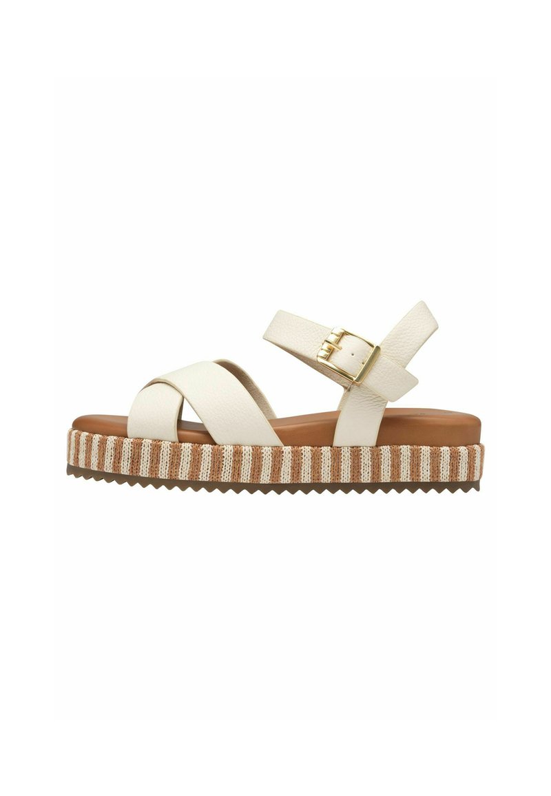White leather platform sandals with crisscross straps, adjustable buckle, and textured brown and cream striped sole.