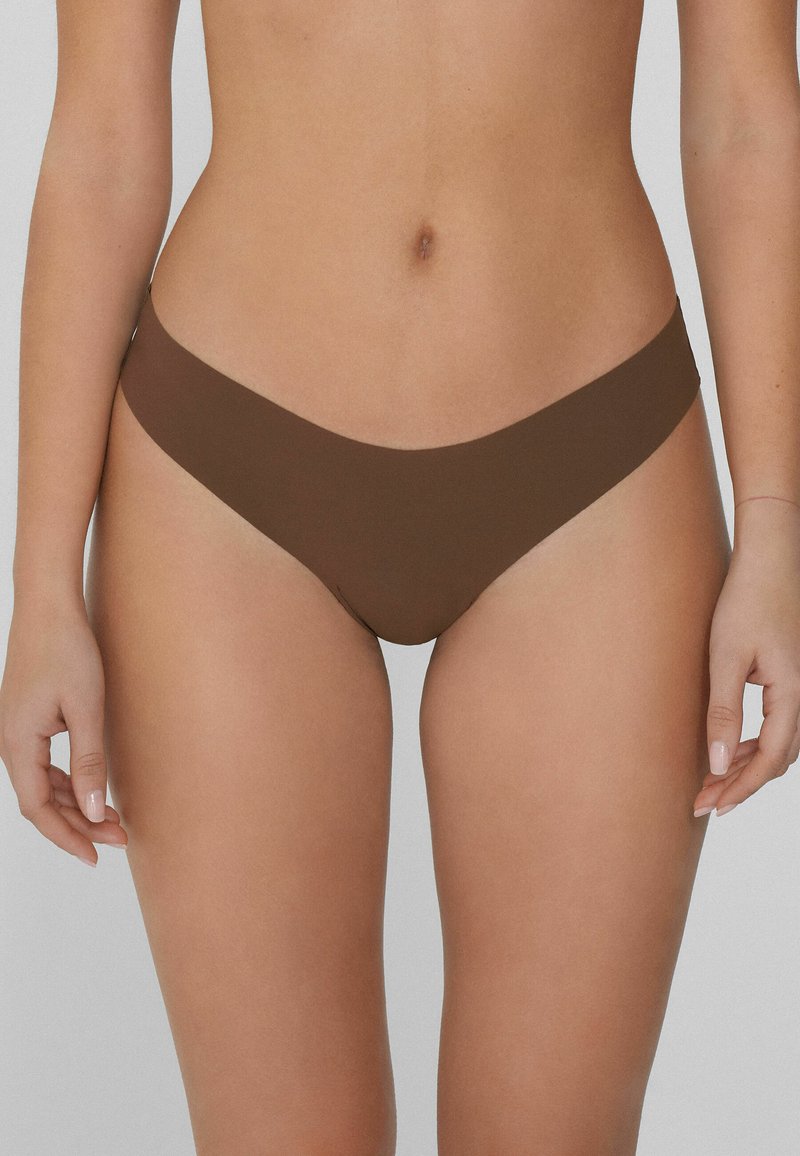 Brązowy bikini w formie dolnej z niskim stanem, gładką teksturą i minimalnym zakryciem, wykonany z elastycznego, lekkiego materiału.