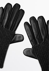 Zwarte leren handschoenen met geribbelde wollen manchetten. Het ontwerp heeft vijf vingers en een gladde, gestructureerde afwerking van het leer.