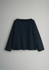 Tumesinine pika varrukaga pluus laia kaelusega, valmistatud pehmest kangast, lõdva lõike ja veidi ümarate äärega. Ilma mustrite või lisanditeta.