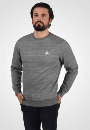 Gray crewneck sweatshirt made of a textured fabric, featuring a small white triangle logo on the chest. Long sleeves and ribbed cuffs.