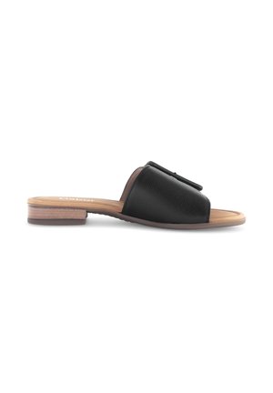 Black leather open-toe slide sandal with low stacked heel and tan footbed, side view on white background.