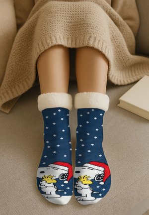 Calzini blu navy con pois bianchi e bordo in peluche bianco, con un cane dei cartoni animati che indossa un cappello di Babbo Natale e fiocchi di neve.