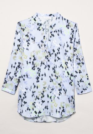 Blusa azzurra a maniche lunghe con stampa floreale astratta nera, bianca, verde e grigia e collo a V spaccato.