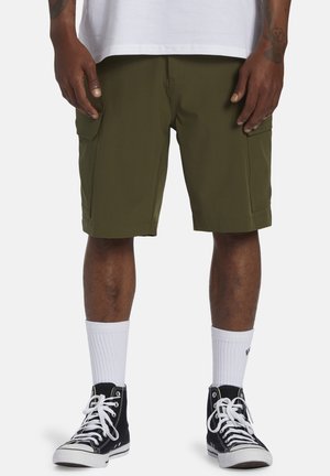 Olivengrønne cargo shorts med sidelommer, lavet af letvægtsstof. Kombineret med sorte høj-top sneakers og hvide crew-sokker.
