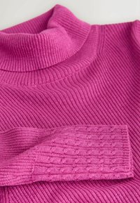 Priliehavý, rebrovaný rolák vo žiarivej ružovej farbe. Má textúrovaný, mierne preložený rukáv s káblovým vzorom. Mäkký materiál.