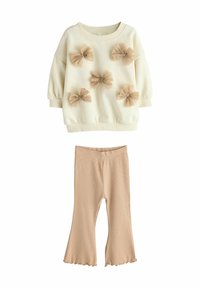 Creme sweatshirt med fem beige tyl-bowser, parret med beige ribstrikkede flared leggings. Blødt stof, afslappet pasform og ribbede manchetter.