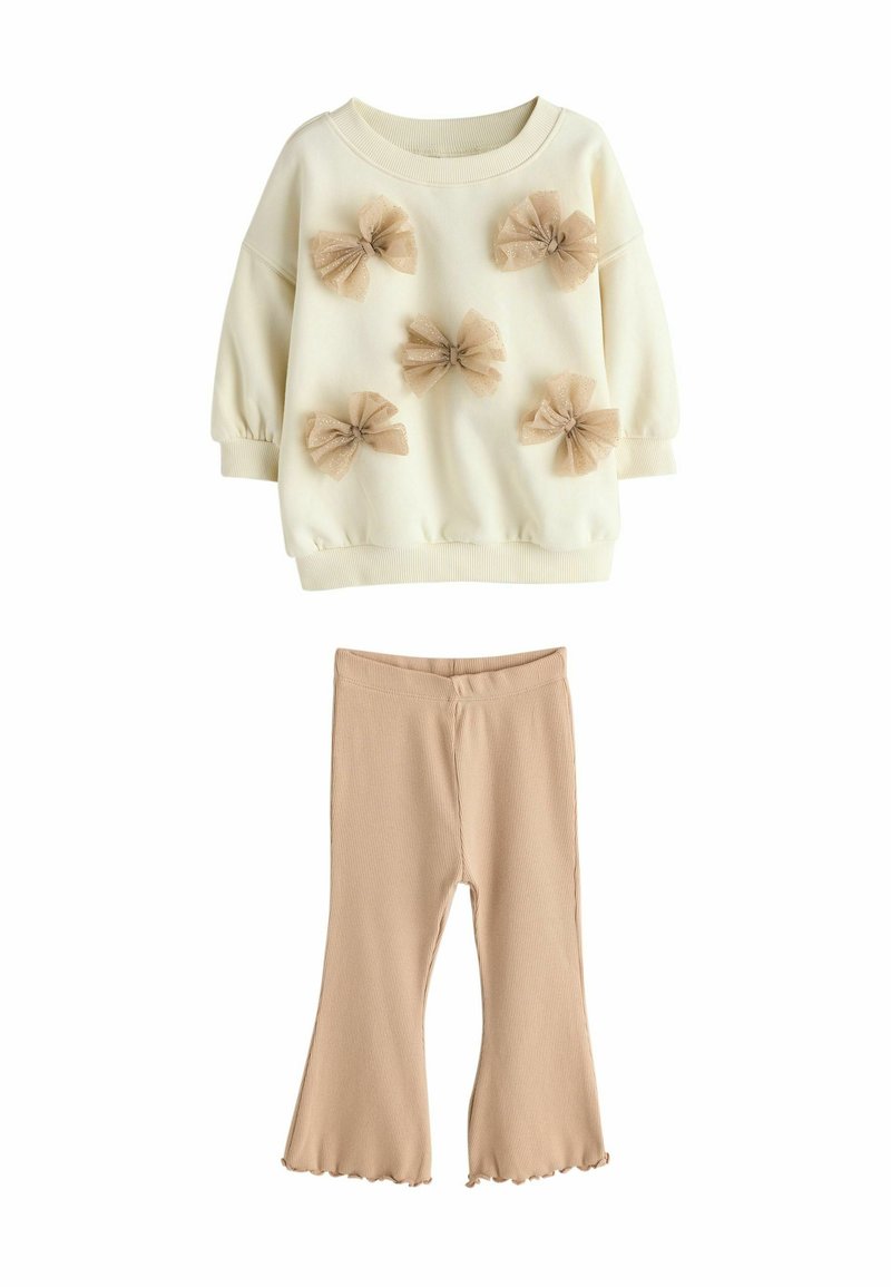 Creme sweatshirt med fem beige tyl-bowser, parret med beige ribstrikkede flared leggings. Blødt stof, afslappet pasform og ribbede manchetter.