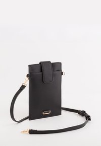 Černá crossbody taška z umělé kůže s klopovým zavíráním, nastavitelným popruhem a zlatými kovovými doplňky. Jednoduchý obdélníkový design.