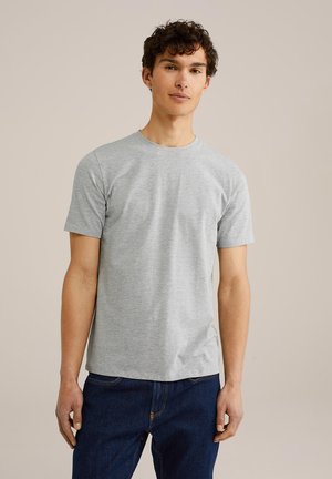 Grå kortärmad T-shirt i bomull, med en enkel rund halsringning och en avslappnad passform, bärs tillsammans med mörkblå denimjeans.
