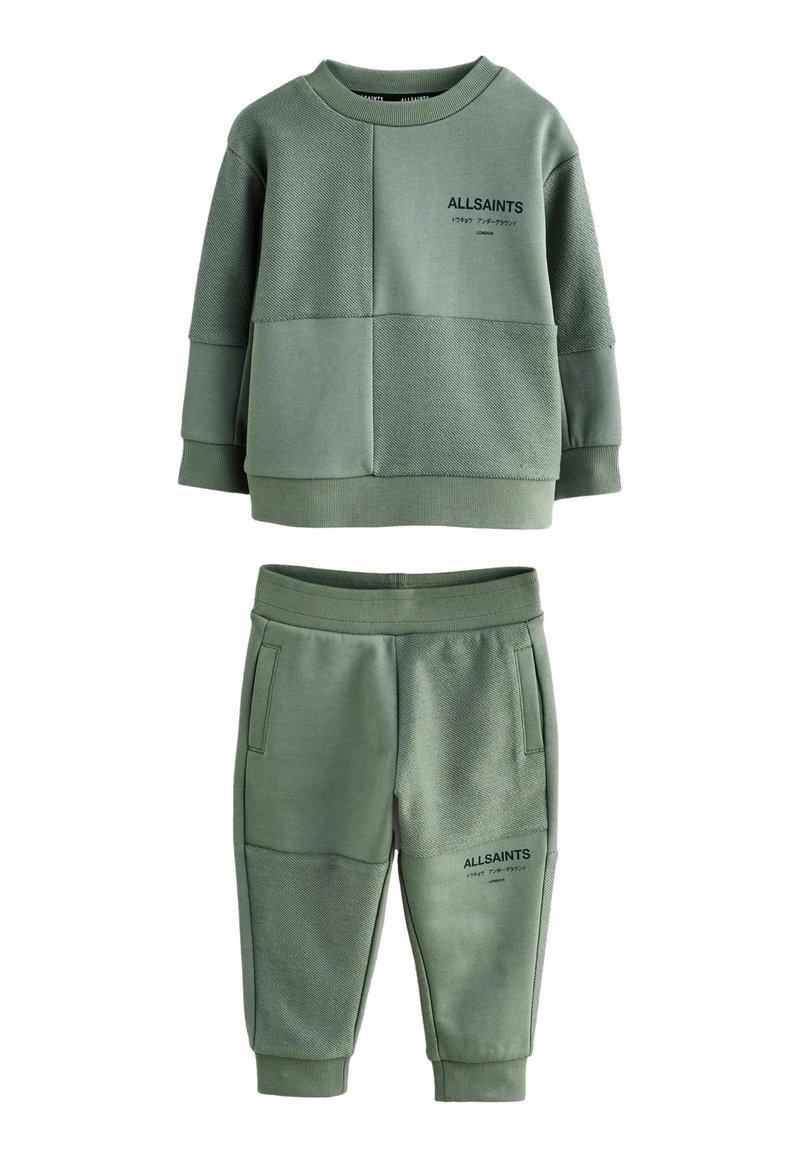 Conjunto de chándal infantil en verde oliva, que incluye una sudadera de cuello redondo con texto y paneles texturizados, combinada con pantalones de cintura elástica.