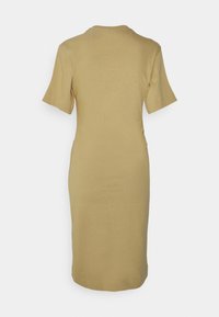 Fitted, knälång klänning i ljust beige tyg. Korta ärmar, rund halsringning och subtila sidofållningar för formgivning.