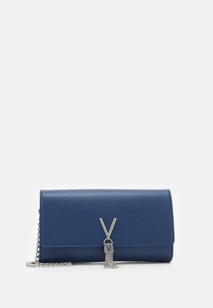 Pochette en cuir bleu avec bandoulière en chaîne argentée et fermoir argenté en forme de V avec pampille sur le rabat avant.