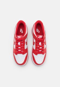 Adidași Nike roșii și albi cu un design sportiv, având un superior din plasă, cutie pentru degete perforată și șireturi plate; detaliu distinct al logo-ului Swoosh.