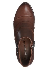 Chaussure en cuir marron avec un bout arrondi, des panneaux texturés et un détail de zip sur le côté. L'étiquette intérieure indique "38". Fini lisse, design épuré.