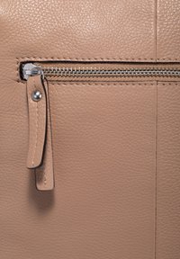 Tasca con cerniera in pelle beige dalla finitura texturizzata, dotata di cerniera in metallo argentato e un piccolo tirante in pelle.