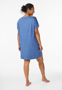 Camicia da notte blu a maniche corte con vestibilità relaxed, caratterizzata da dettagli in pizzo sulle spalle e una trama liscia e morbida.