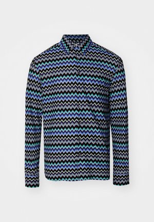 Camisa de hombre de botones, con base negra y patrones en zigzag en azul, verde y blanco. Manga larga y cuello clásico. Textura de tela suave.