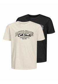 Divas T-kreklu komplekts, viens krēmkrāsas un otrs melns. Abiem ir apaļš kakla izgriezums un uz tiem ir redzams teksts "JACK&JONES Coll. Studio" bieza melna burtiem.