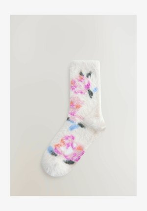 Pluizige witte sok met kleurrijke bloemmotieven in roze, oranje, blauw en zwart. Zachte textuur, aansluitende pasvorm, afgeronde teen.