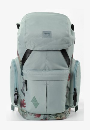 Mintgrüner Rucksack mit floralen Akzenten, verstellbaren Trägern, mehreren Taschen und einem schwarzen Logoetikett auf der Vorderseite.