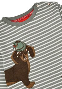 Gestreiftes langärmliges Shirt in Grau und Weiß mit einem braunen Dackel-Applikation und einem grünen Hut. Mit Metallic-Knöpfen an der Schulter.