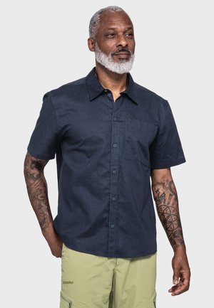 Navy short-sleeve shirt in a lightweight fabric featuring a chest pocket and button-down collar. Tattoos visible on the arm.