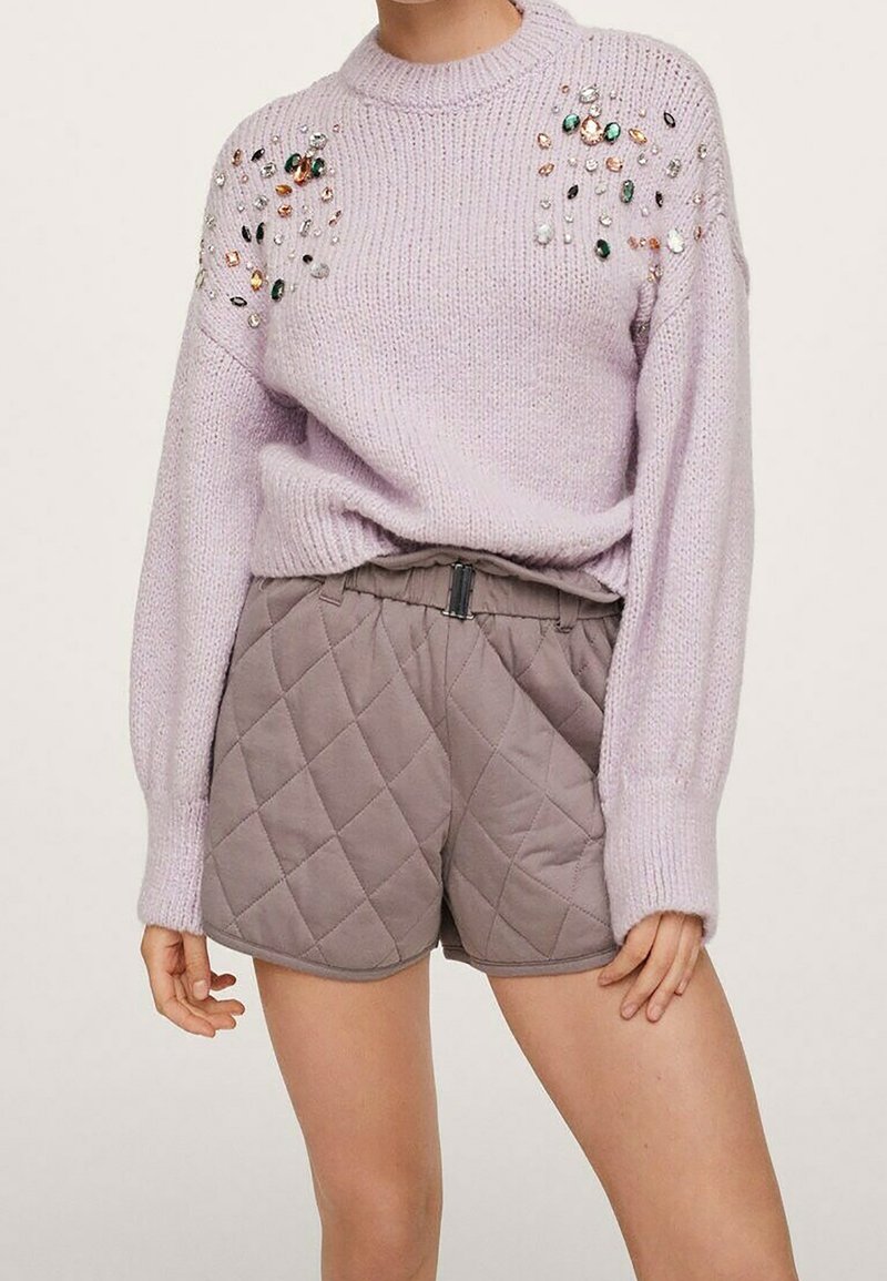 Pull en tricot lilas avec décorations de perles multicolores sur les épaules, associé à un short matelassé taupe taille haute.