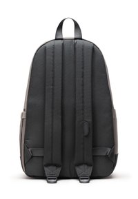 Černý látkový batoh s hladkým povrchem, polstrovaným zadním dílem, dvěma ramenními popruhy a horním madlem. Obsahuje boční kapsy a zipové uzavření.