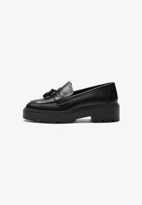 Schwarze Lederloafers mit einem markanten Riemen und Quasten-Detail, ausgestattet mit einer klobigen, strukturierten Plateausohle. Glatte Oberfläche und flache Form.
