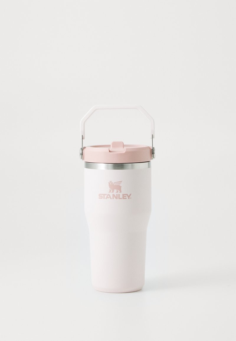 Mug isolé blanc avec un couvercle et une poignée rose, doté d'un rebord en métal. L'avant affiche le logo "STANLEY" en rose. Texture lisse.