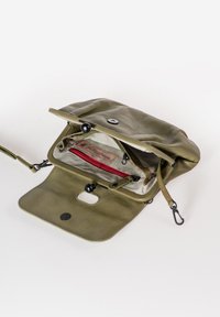 Borsa in pelle verde oliva con finitura texturizzata, chiusura a scatto e fodera in tessuto a righe. Include una tasca con zip rossa e tracolla regolabile.