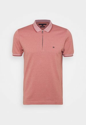 Polo da uomo a maniche corte color rosa polvere con zip frontale, collo e polsini a coste e piccolo logo sul petto sinistro.