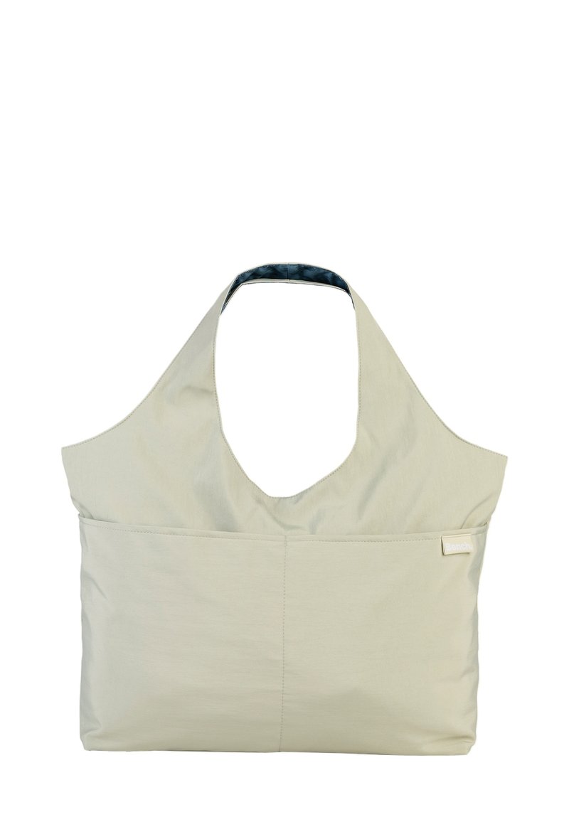 Lichtbeige stoffen draagtas met een groot, open ontwerp, een brede schouderband, een enkele voorkantzak en een blauwe binnenvoering.