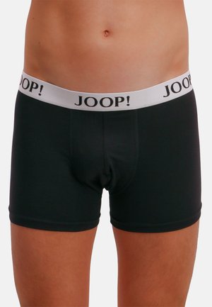 Černé boxerky s bílým elastickým pasem, na kterém je černým písmem napsáno jméno značky "JOOP!". Hladká látka a přiléhavý střih.