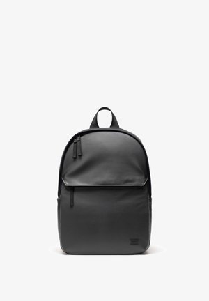 Sac à dos en cuir noir, de forme arrondie, avec fermeture à double zip, poche frontale et anse supérieure. Texture lisse avec un détail de logo embossé.