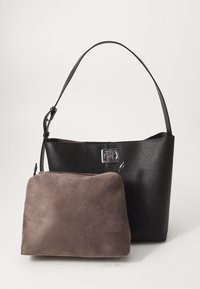 Sac à épaule en cuir noir texturé avec une sangle réglable et une fermeture argentée, associé à une petite pochette en daim marron à l'avant.
